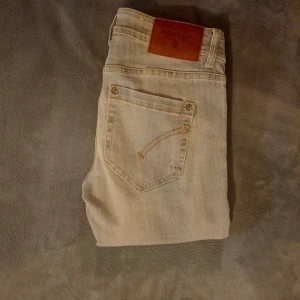 Dondup jeans - Säljer ett par riktigt snygga dondup jeans med slitningar. Det är en äldre modell med den gamla dondup loggan bak på fickan. Storleken är 26 vilket är liten storlek, motsvarar XXS, passar dig som är ca 152. Skriv vid minsta frågor eller funderingar