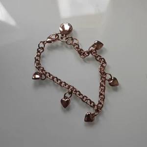 Roseguld armband med hjärtberlocker - Snyggt armband i roseguld från SNÖ OF SWEDEN med flera små hjärtberlocker som hänger längs kedjan. 