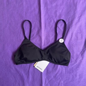Bikiniöverdel från monki (med prislapp) - Svart bikinitop från Monki. Aldrig använd med prislappen kvar. Nypris 180 kr.