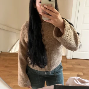 Beige teddyjacka med dragkedja - Supermysig beige teddyjacka med dragkedja framtill och breda ärmar.