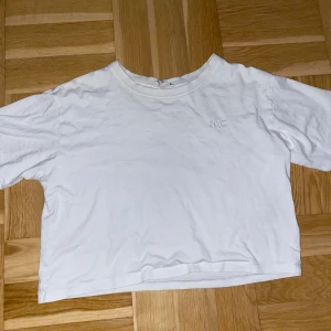 Vit croppad t-shirt med NYC-tryck - Vit croppad t-shirt från H&M med broderat NYC-tryck