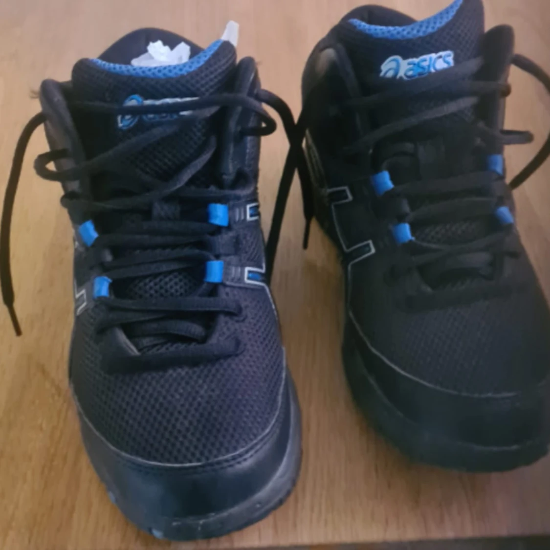 Svarta Asics sneakers med blå detaljer