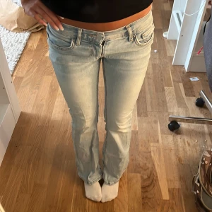 LOWWAIST bootcut jeans - Säljer ett par ljusblå jeans med bootcut passform och låg midja. Jeansen har klassiska fem fickor, dragkedja och knapp framtill. Perfekta för dig som gillar en avslappnad men ändå snygg stil.