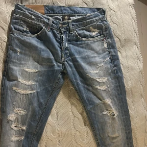 Dondup Jeans - Riktigt schyssta jeans som är en riktig komplimang-magnet🤩🤩😮‍💨😮‍💨 De är ett par ljusblå skinny jeans med slitningar och hål på framsidan. Jeansen har klassisk femficksdesign och är tillverkade i denim med en snygg tvättad look.  