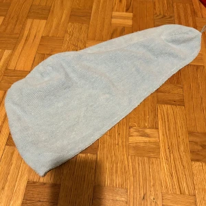 Ljusblå frotté turbanmössa - Säljer en ljusblå turbanmössa i mjuk frotté med elastisk ögla för enkel fastsättning. Perfekt att använda efter dusch eller bad för att hålla håret på plats. Materialet är 90% polyester och 10% polyamid, vilket gör den superabsorberande och lätt.