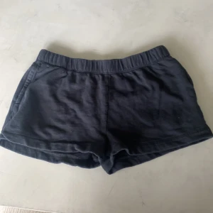 Svarta mjuka shorts från lager 157. - Svarta shorts från 157  i storlek 140. De har en elastisk midja och är gjorda i mjuk bomull, vilket gör dem riktigt sköna. Modellen är loose fit och har praktiska fickor på sidorna. Perfekta för chill dagar under sommaren.