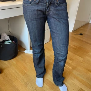 Mörkblå raka jeans från Lee - Säljer ett par klassiska mörkblå jeans från Lee Women med raka ben och låg midja . Jeansen har normal passform och är tillverkade i slitstark bomullsdenim. Perfekta för dig som gillar en tidlös och clean look.