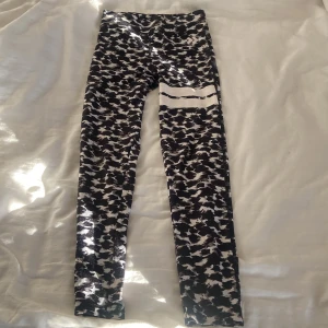 Träningsbyxor från lager 157  - Snygga leggings från 157 i svart och vitt camouflagemönster. De har en cool vit rand på ena benet. Perfekta för träning eller chill, med stretchigt material som sitter skönt hela dagen.