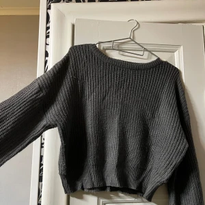 Mörkgrå stickad tröja från Boohoo - Säljer en mörkgrå stickad tröja från Boohoo i storlek M. Tröjan har en croppad men figurnära passform, bred ribbstickning och långa ärmar. Rund halsringning och mjukt material som gör den väldigt bekväm