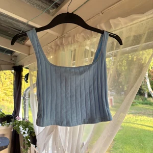 Ljusblå ribbad linnetopp från Shein - Supersöt ljusblå croppad linnetopp från Shein i ribbad bomull. Toppen har breda axelband och fyrkantig ringning, perfekt till jeans eller kjol. Enkel och fräsch stil som passar till varma dagar.