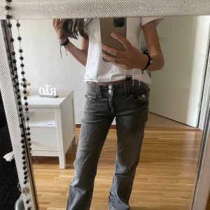 Grå bootcut jeans med dubbla knappar - Säljer ett par gråa jeans med lådmidja, bootcut-modell och dubbla knappar i midjan. Köpta på Ginatricot i storlek 152 (barnstorlek) men passar XS. 