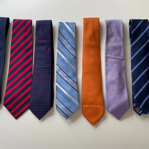 Färgglada slipsar i olika mönster - Säljer ett gäng snygga slipsar i olika färger och mönster. Här finns randiga i blått, rött och brunt, en orange med små prickar, en lila och en mörkblå med diskreta rutor. Perfekt för dig som vill sticka ut med din stil och variera din look. Slipsarna kommer från olika små företag från runt om i världen.