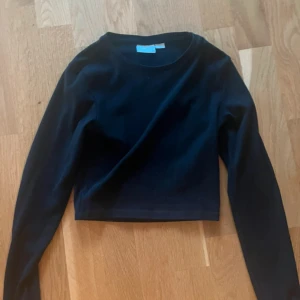 Svart croppad långärmad tröja Gina Tricot - En svart, croppad långärmad tröja från Gina Tricot. Enkel och stilren modell med rund halsringning, perfekt att matcha med  jeans eller kjol. Endast använd ett fåtal gånger. Storlek 146/152. Finns att hämta strax utanför Göteborg. Skickas mot att köparen står för frakten,