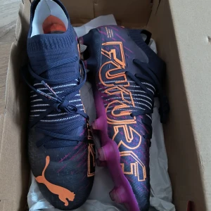 Puma Future Z 1.2  strl 43 - Säljer ett par Puma Future Z 1.2 FG/AG fotbollsskor i storlek 43. I absolut nyskick! Endast testad 5 min på konstgräs och sedan packeds igen i box. Passade inte. Nypris över 2500kr