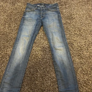Blå jeans Jack&Jones - Klassiska blå jeans från Jack&Jones med snygga slitna detaljer framtill. Jeansen är storlek |W29|L30| och är modellen slim Glenn. 