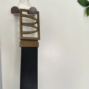 Svart skärp med unik metallspänne - Stilrent svart bälte i skinn med McDonald’s loggan.  