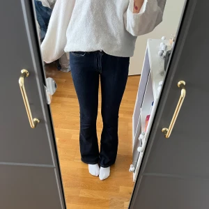 Bootcut jeans från Gina Tricot - Mörkblå bootcut jeans från Gina Tricot, modell Perfect Jeans. Klassisk femficksdesign, snygga kontrastsömmar och normal passform. Jeansen är tillverkade i stretchig denim för extra komfort och har en tidlös look.