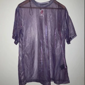 Lila mesh lång T-shirt i transparent material - Säljer en lila transparent mesh lång T-shirt. Toppen har en oversize passform 