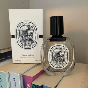 Diptyque Fleur de Peau Eau de Toilette - Diptyque Fleur de Peau Eau de Toilette i 50 ml flaska. Doften kommer i en elegant oval glasflaska med svart lock och klassisk vit etikett med svart tryck. Förpackningen är vit med samma grafiska design och text. Perfekt för dig som gillar exklusiva och unika dofter. Helt ny!