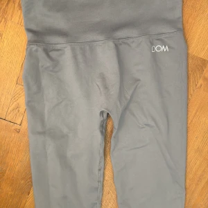 Grå leggings från Drop of Mindfulness - Snygga grå leggings från Drop of Mindfulness med hög midja och ribbad linning. Tillverkade i stretchigt material som sitter skönt och följer kroppen. Perfekta för träning eller chill dagar. Diskret logga på höften.