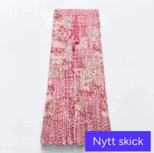 Rosa mönstrad långkjol med volang - Säljer en rosa långkjol med blandade mönster och volangdetaljer från Zara. Kjolen har knytband i midjan och är luftig och flowy, perfekt för varmare dagar. Älskar denna kjol och skriv för fler bilder och om ni har frågor! 💕