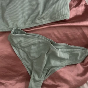 Ljusgrön ribbad bikini med crop top - Säljer en ljusgrön bikini med crop top och smala axelband. Bikinin är ribbad och har en enkel, sportig design. Underdelen är klassisk med normal passform. Perfekt för strand eller pool!  50 kr Knappt använd 