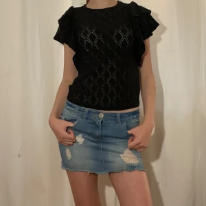 Svart topp med volangärmar från Holly & Whyte - Säljer en svart topp från Holly & Whyte  med volangärmar. Toppen har ett diskret rutmönster. Perfekt för dig som vill ha något extra till outfiten! 💗💗