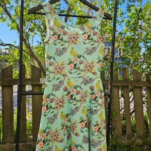 Blommig mintgrön klänning - Superfin mintgrön klänning med blommigt mönster i rosa, gult och lila. Ärmlös modell med rund halsringning och markerad midja. Perfekt för varma dagar och somriga tillfällen.