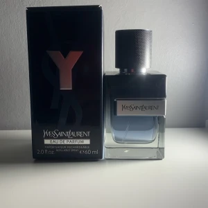 Yves Saint Laurent Y Eau de Parfum 60 ml - Y Eau de Parfum från Yves Saint Laurent i en stilren glasflaska med metallock. Doften är maskulin och modern, perfekt för dig som gillar fräscha och träiga toner. Flaskan rymmer 60 ml och kommer i originalförpackning. Drygt 55 ml kvar har knappt använt. Gillar doften extremt mycket men min efterblivna tjej tycker inte samma tyvärr så måste få av den ifrån hyllan.