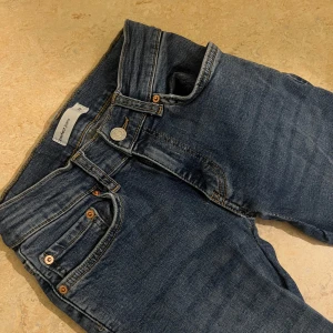 Blå bootcut jeans från Gina Tricot - Säljer ett par blå jeans från Gina Tricot med bootcut-ben och normal passform. Jeansen är låg midjade. Perfekta till vardags med en t-shirt eller stickad tröja.💗