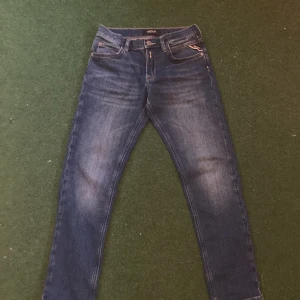 Blå jeansbyxor från Replay - Säljer ett par klassiska blå jeansbyxor från Replay. Byxorna har fem fickor, raka ben och normal passform. Perfekta för dig som gillar en tidlös stil med snygga detaljer och bekvämt material. Använda 1 eller 2 gånger