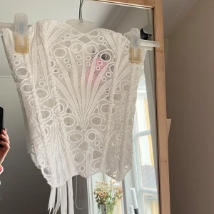 Vit broderad korsett med snörning - Säljer en vit korsett från prettylittlething med broderade detaljer och snygg snörning i ryggen. St UK 6. 