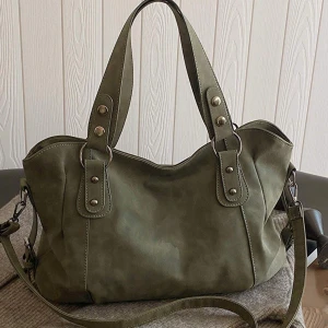Olivgrön axelväska med detaljer - Snygg olivgrön axelväska med både handtag och justerbar axelrem. Väskan har silverfärgade metalldetaljer och en stilren design som passar till många outfits. Perfekt storlek för att få plats med allt du behöver under dagen.