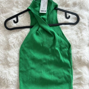 Grön twistad ribbad linnetopp -  ribbad topp med twistad halterneck, oanvänd 