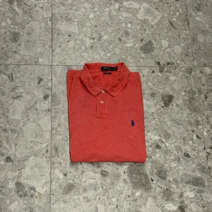 Korallröd pikétröja från Polo Ralph Lauren - Säljer en korallröd pikétröja från Polo Ralph Lauren. Ett väldigt bra val till sommaren. Inte bästa kvaliten därav priset på denna. Nypris cirka 1500kr
