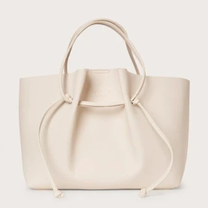 Beige handväska från Stockholm Studio - Snygg beige handväska från Stockh lm i skinn. Väskan har en stilren design och är jätte rymlig och smidig då man kan ändra ”storlek” med hjälp av att justera banden! Har lite fläckar på insidan men ser i princip helt ny ut utifrån! Skriv vid frågor🥰 ca 33 x 42cm 🍸🪩🐆