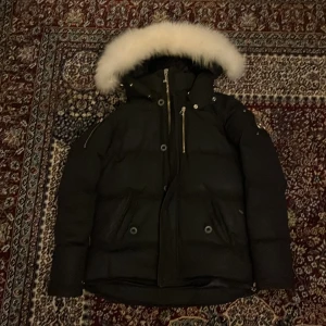 Svart dunjacka Moose Knuckles - Säljer en svart dunjacka från Moose Knuckles med fluffig vit pälskant på huvan. Jackan har dragkedja, knappar och flera fickor framtill. Har tröttnat på jackan o vill sälja den för ett rimligt pris. Skriv till mig så diskuterar vi pris. Skriv också till mig om ni vill ha fler bilder. Adda snap också om ni vill ha svar från mig snabbare o skriva gärna här att ni har addat mig så jag vet. (Nb.68o/Snap) 😊