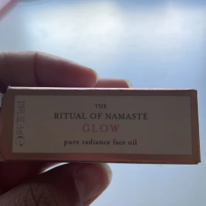 Ritual of Namasté Glow Face Oil - Glow Pure Radiance Face Oil från Ritual of Namasté. En ansiktsolja i glasflaska med rosa lock, 5 ml. Oljan innehåller bland annat sötmandel, jojoba, aprikos och solrosolja för en återfuktande och glowig finish. Perfekt för dig som vill ha extra lyster i din hudvårdsrutin. Ser lite grumlig ut om den är skakad! 🫶