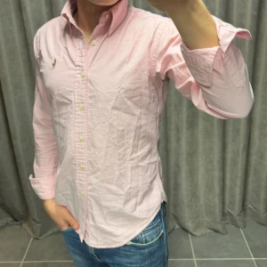 Ralph Lauren Skjorta - Rosa skjorta från Ralph Lauren i strl XS/S och skjortan håller ett mycket bra skick, killen på bilden är 174 cm lång
