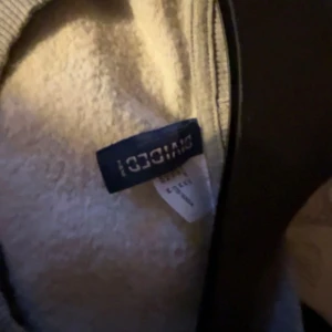 Grå sweatshirt med NYC-tryck Divided - Säljer en grå sweatshirt från Divided med färgglatt NYC Urban Jungle-tryck framtill. Tröjan har rund hals, långa ärmar och ribbade muddar. Perfekt för dig som gillar streetstyle och vill ha en bekväm och snygg tröja till vardags.