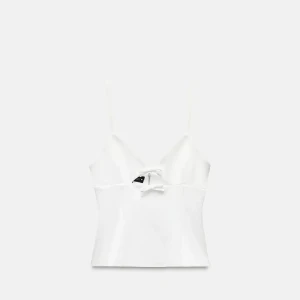 Vit Zara topp med rosett - Supersöt vit topp. Toppen har v-ringning och croppad passform som ger en trendig look. Perfekt att styla med jeans eller kjol för en fräsch vibe.