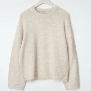 Beige stickad tröja  - Mysig beige stickad tröja med rund halsringning och ribbade muddar vid ärmslut och nederkant. Tröjan har en avslappnad passform och är perfekt att slänga på sig till jeans. Enkel och stilren design som funkar året om.