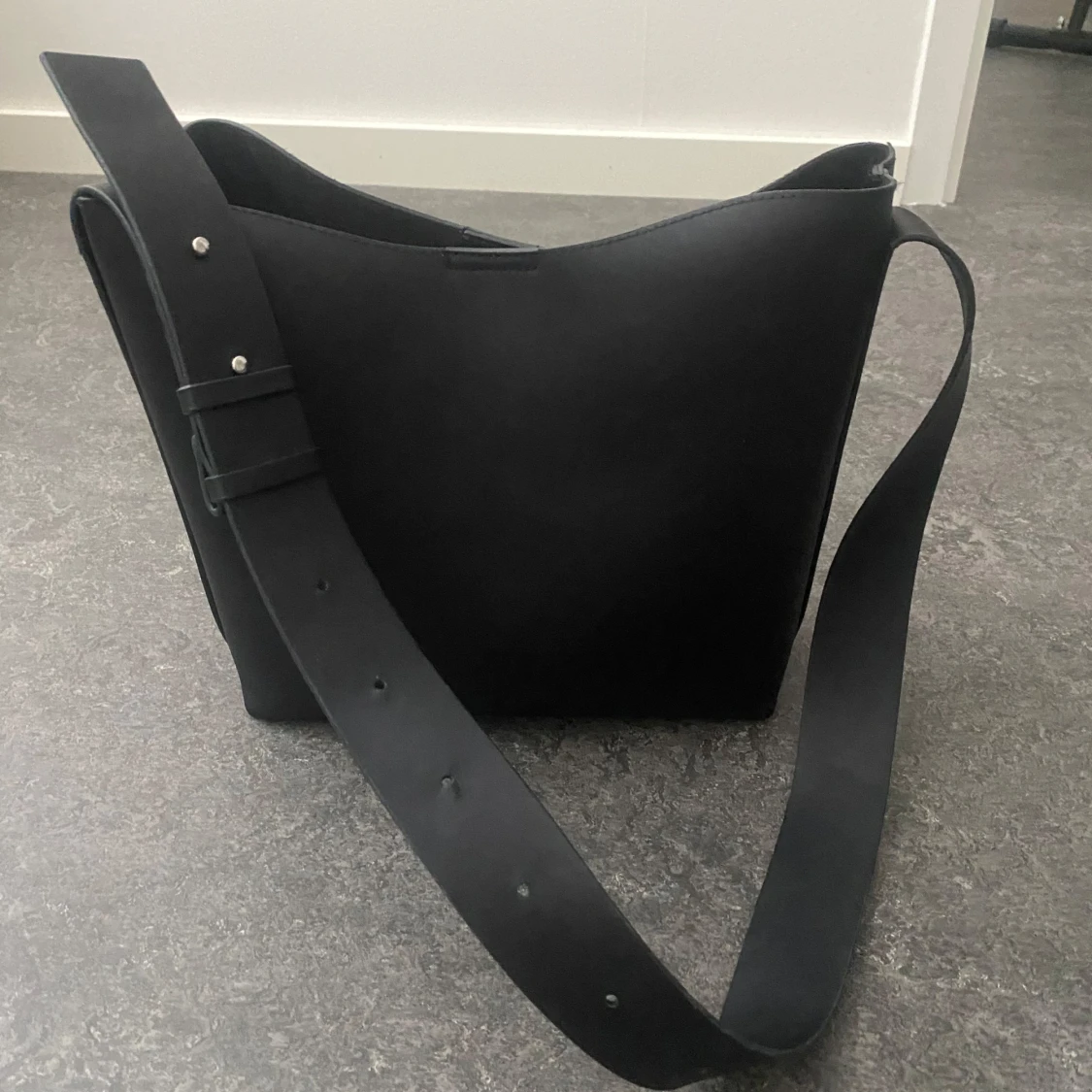 Svart axelväska i skinn med bred rem