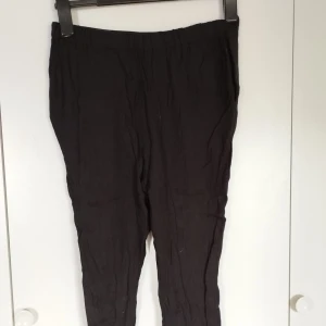 Svarta mysbyxor som andas - Svarta mysbyxor från DeFacto i avslappnad passform. Byxorna har elastisk midja och raka ben, perfekta för en chill och stilren look. Materialet är lätt och luftigt, vilket gör dem sköna att bära under varmare dagar. Säg till om du vill ha bild på hela varan; Bilderna beskärs så dumt i appen.