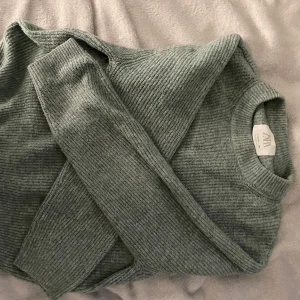 Grön ribbad stickad tröja från Zara - Mysig grön stickad tröja från Zara i storlek 164. Tröjan har ribbad struktur, rund halsringning och långa ärmar. Perfekt för dig som gillar en enkel men snygg stil.