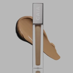 CAIA concealer i beige nyans - Concealer från CAIA i en snygg beige ton. Kommer i en stilren, fyrkantig genomskinlig tub med silverfärgat lock. Perfekt för att täcka mörka ringar och ojämnheter. Enkel att applicera med smidig applikator.