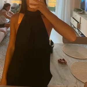 Svart halterneck topp med öppen rygg - Svart halterneck topp med hög hals och helt öppen rygg! Så så snygg men lite stor på mig tyvärr!☺️💗
