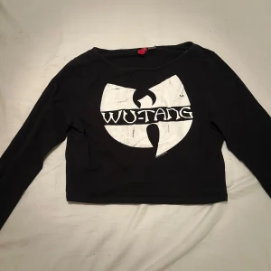 Svart Wu Tang Clan tröja - Svart croppad långärmad tröja från H&M. Den är verkligen inte i storlek L skulle säga S