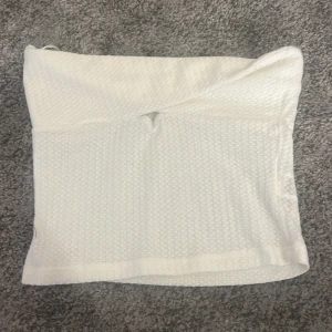 Tubtop ifrån SHEIN  - Supersnygg vit linnetopp med twistad detalj framtill och smala axelband. Toppen har en strukturerad, småmönstrad yta och sitter tajt men bekvämt. Perfekt till svarta byxor eller jeans för en fräsch look.