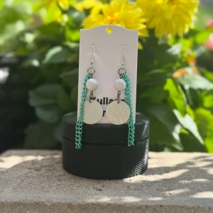 Örhängen i turkos och vita färger  - Unika handgjorda örhängen – “Ocean Breeze”  Låt dina öron få glänsa! Dessa handgjorda örhängen kombinerar vit, elegant keramiklook med turkosa länkar som påminner om havets vågor. Lätta att bära, lätta att älska – perfekta för både vardag och fest! 	•	Nickelfria krokar 	•	Färger: Vit & turkos 	•	Varje par är unikt! 